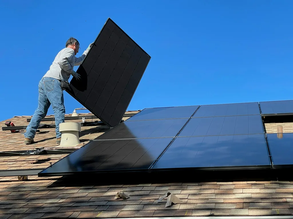 Solar panel installer fitting panels on a rooftop